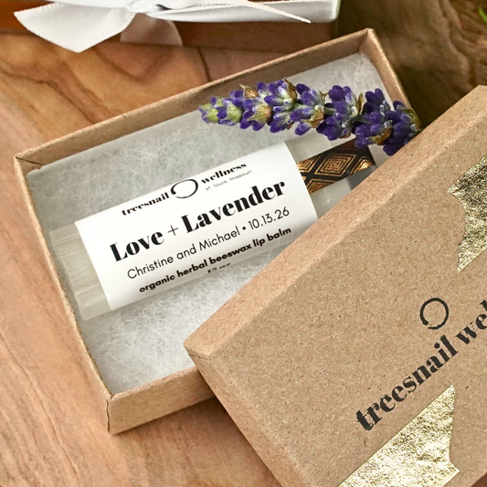 Lip balm labeled 'Love + Lavender' in an eco-friendly box with 'treesnail wellness' branding.