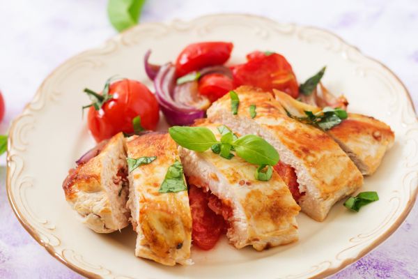chicken, basil, tomatoes on a white plate