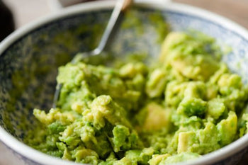 fresh guacamole in a bowl with a spoon
