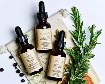 3 natural beard oil bottles laying with rosemary