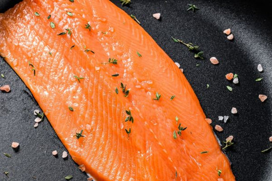 trout in pan with salt and herbs