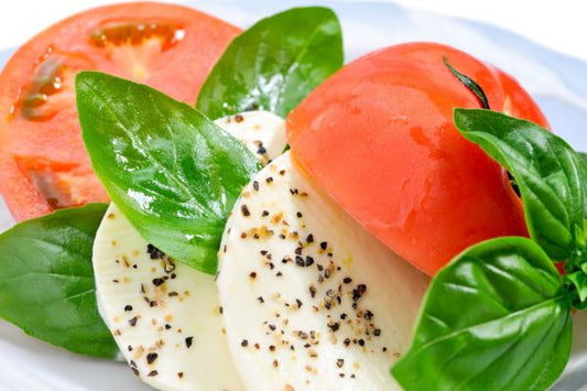 tomato caprese salad that includes tomatoes, basil, mozzarella