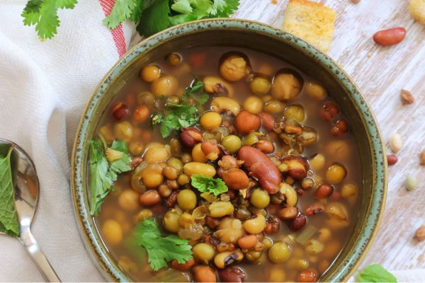 bean and lentil soup in a pot with herbs