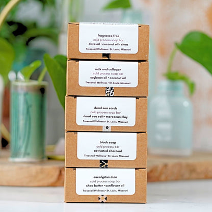 Stack of brown cardboard soap boxes with product labels on a blurred natural background