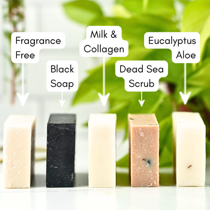 Five bars of soap with labels indicating their ingredients and properties, set against a blurred green leafy background.