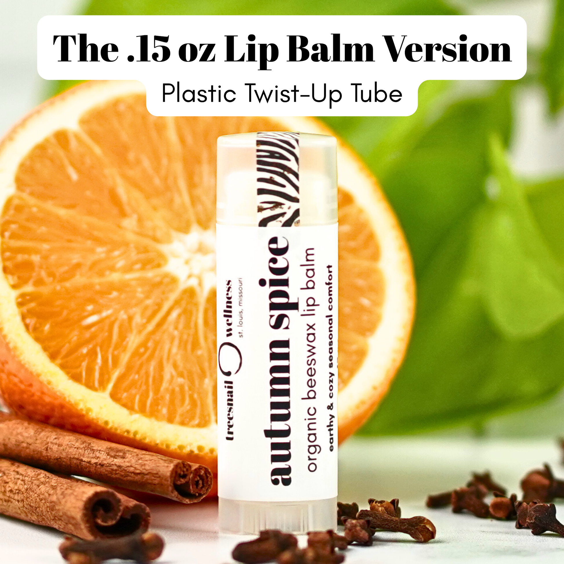 .15 oz. Lip balm in plastic tube labeled 'autumn spice' with an orange, cinnamon stick, and cloves in the background.