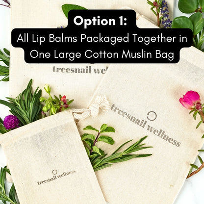 Lip balms packaged in a large cotton muslin bag with 'treesnail wellness' branding, surrounded by greenery and flowers.