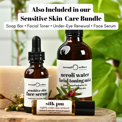 Treesnail Wellness skincare products including a fragrance free soap bar, sensitive skin face serum, neroli water toning mist, and under eye renewal on a wooden surface with a blurred green background.