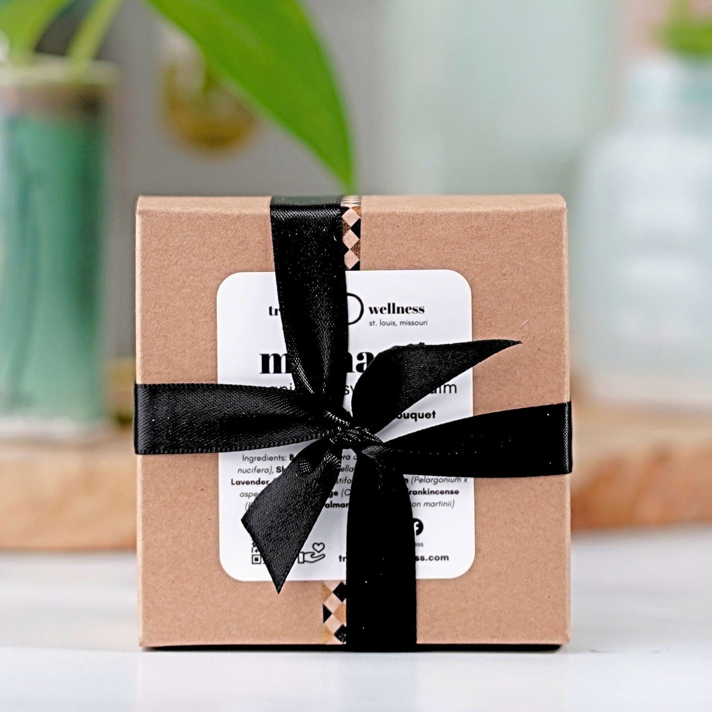 Gift box with a black ribbon on a blurred background
