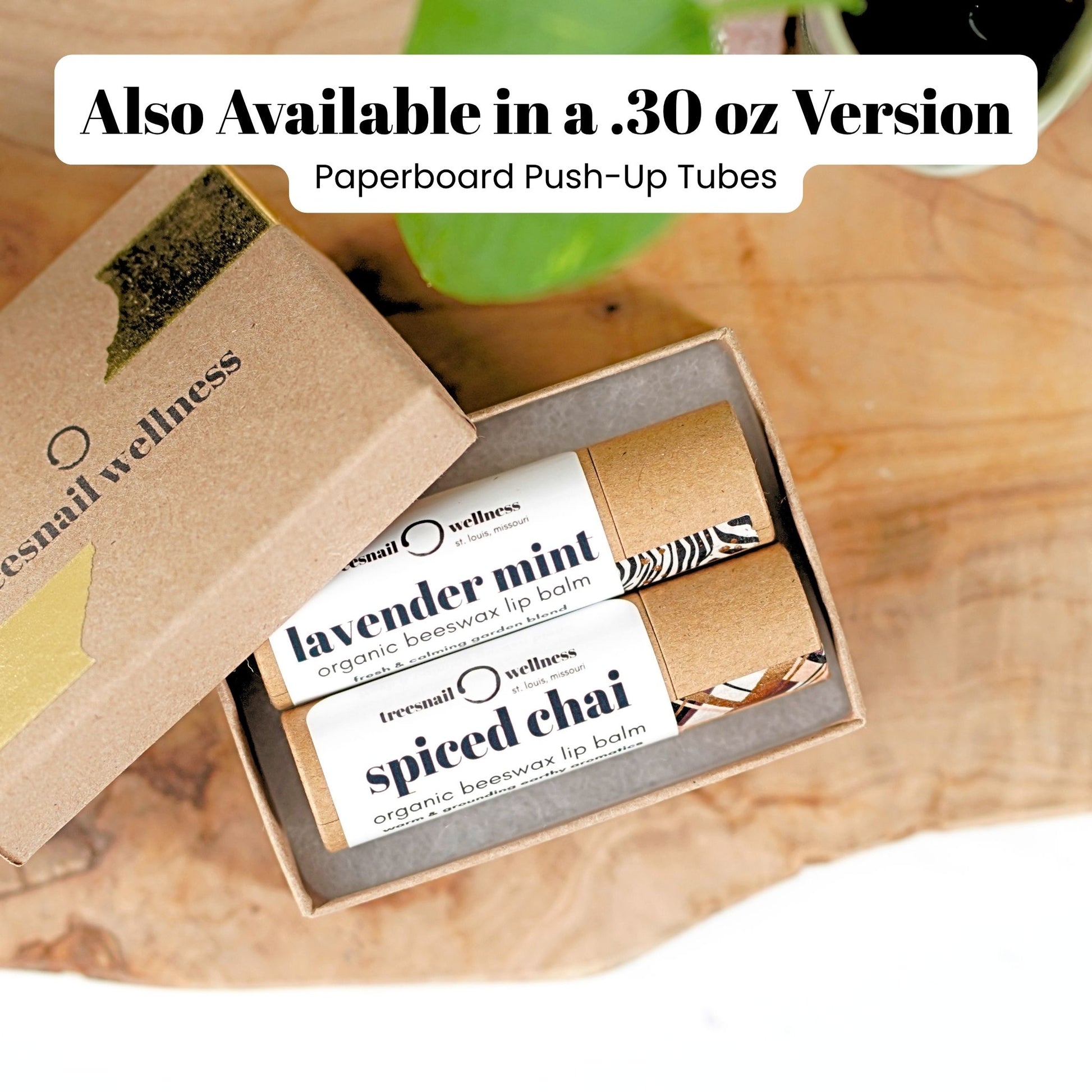 Box of .30 oz organic beeswax lip balms with Treesnail Wellness branding on a wooden surface.